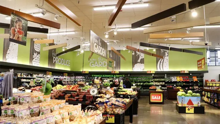 Grocery store produce section with painted ceiling and signage